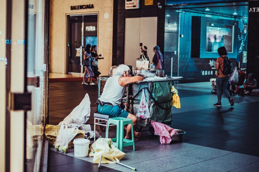 Extreme cleaning situation showing heavily accumulated waste and belongings in a neglected commercial street environment