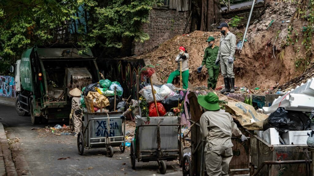 Professional hoarding cleanup crew removing debris and accumulated waste from severely cluttered outdoor area